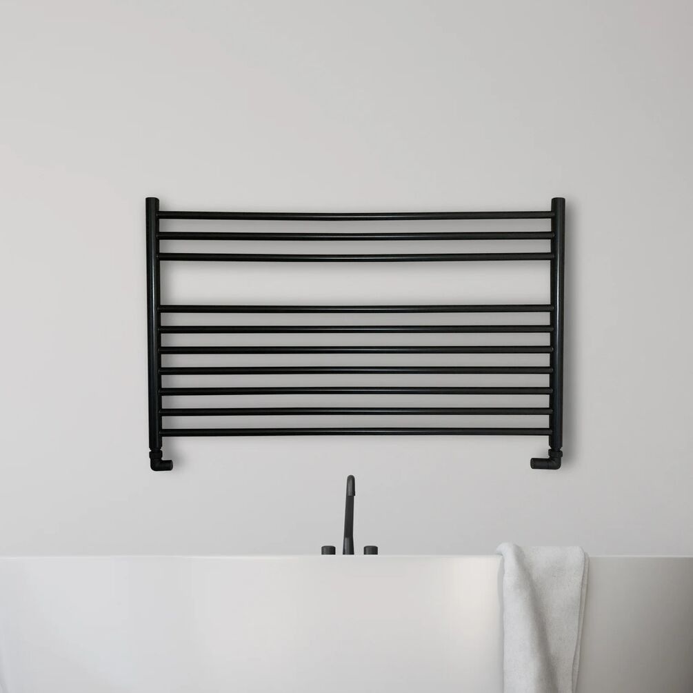 Lifestyle image of the The Sussex Range by JIS Newick 600mm x 1000mm Black Heated Towel Rail wall mounted behind a bathtub